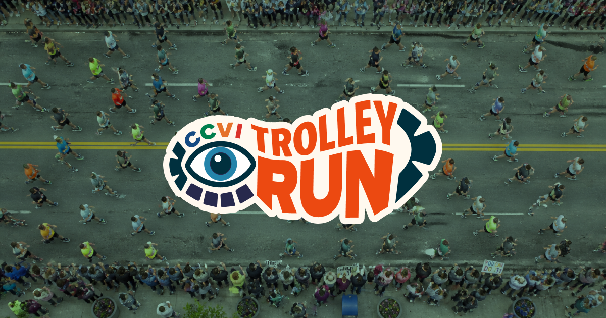 The CCVI Trolley Run logo, an eye built from a sneaker tread, "CCVI" in multicolor blocks above it and "TROLLEY RUN" in bold orange, set over an overhead photo of runners and spectators along the race route.